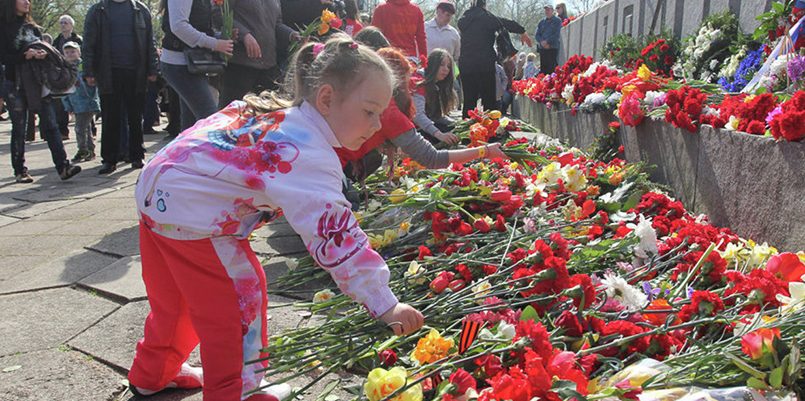 Девочка возлагает цветы к Памятнику Освободителям
